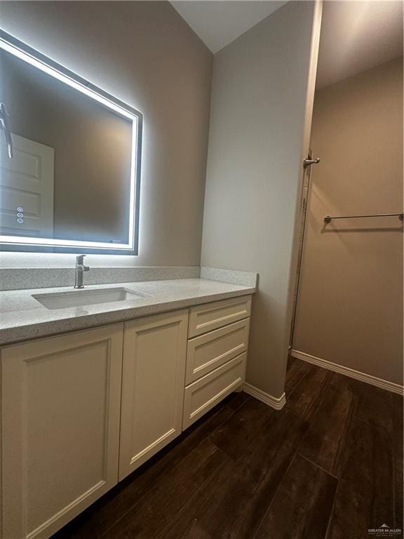bathroom with wood finished floors, vanity, and baseboards