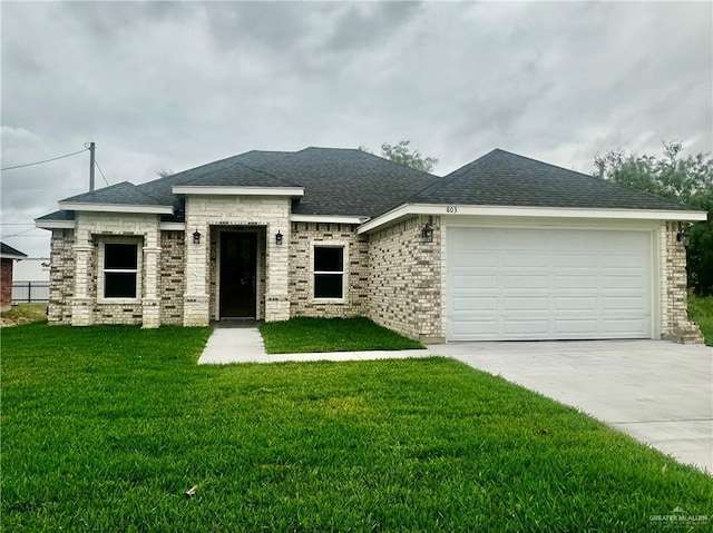 prairie-style house with a garage, a front lawn, concrete driveway, and roof with shingles