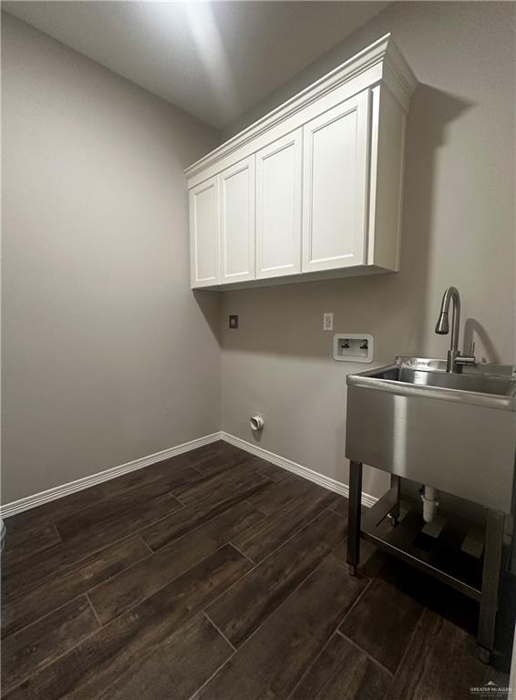 laundry room featuring cabinet space, hookup for a washing machine, dark wood finished floors, and baseboards