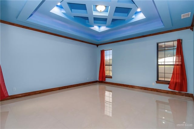 unfurnished room featuring a raised ceiling, a wealth of natural light, coffered ceiling, and ornamental molding