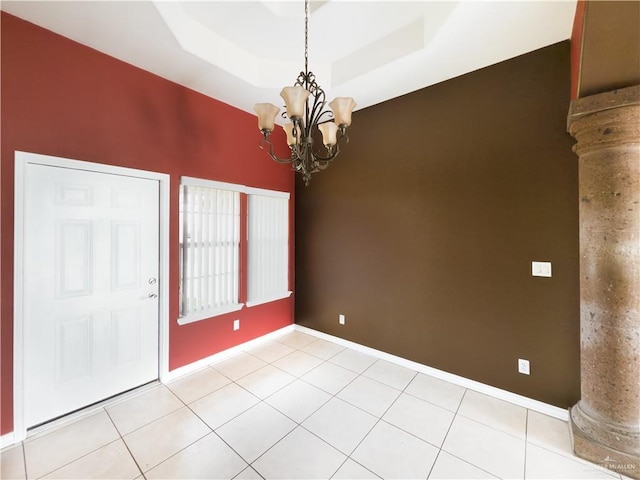 empty room featuring decorative columns, baseboards, an inviting chandelier, and light tile patterned floors