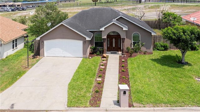 ranch-style home with driveway, a garage, fence, a front lawn, and stucco siding