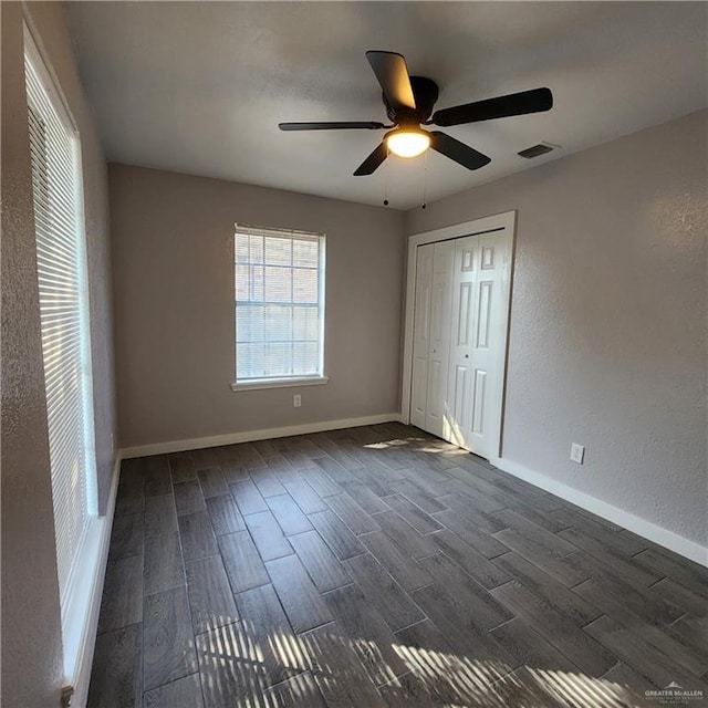 unfurnished bedroom featuring dark hardwood / wood-style flooring, a closet, and ceiling fan