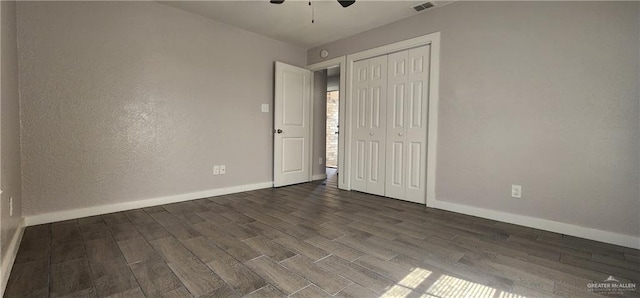 unfurnished bedroom with ceiling fan, dark hardwood / wood-style flooring, and a closet