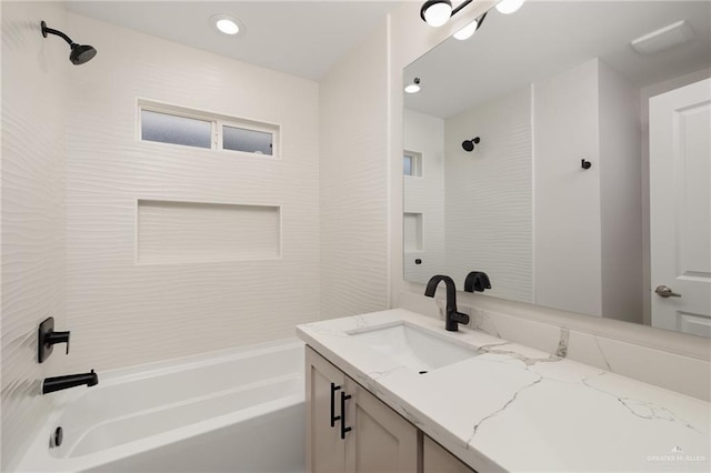 bathroom with tiled shower / bath combo and vanity