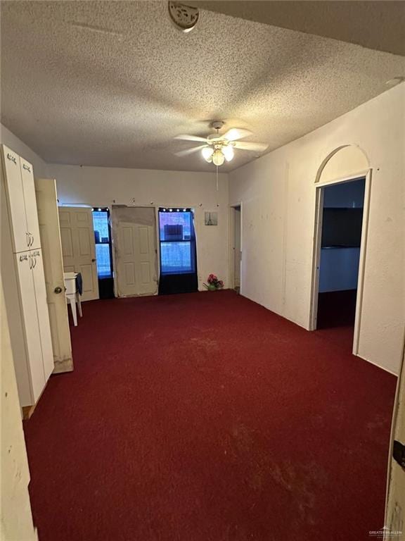 unfurnished room featuring ceiling fan, carpet floors, and a textured ceiling