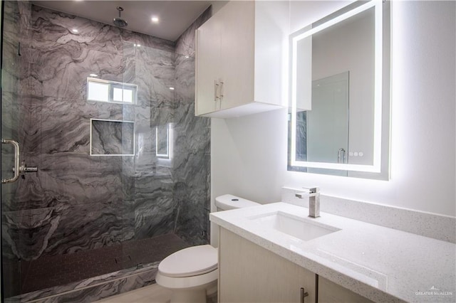 bathroom featuring vanity, toilet, and a shower with shower door