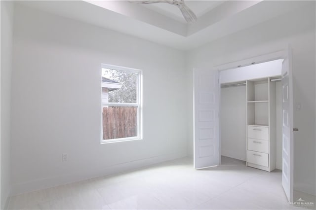 unfurnished bedroom with ceiling fan and a closet