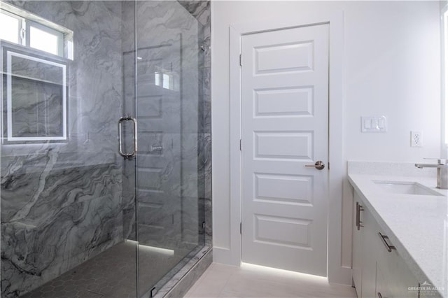 bathroom with tile patterned floors, vanity, and a shower with door