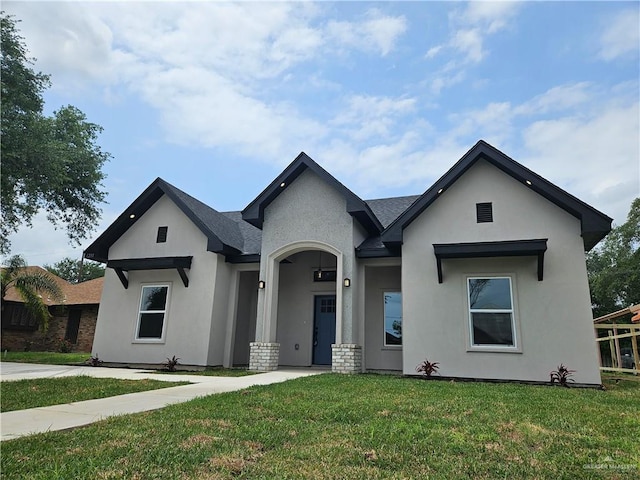 ranch-style house featuring stucco siding and a front lawn