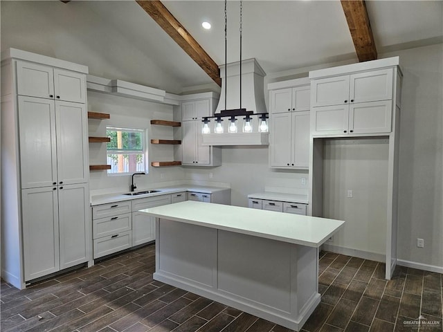kitchen featuring open shelves, wood finish floors, a sink, a kitchen island, and recessed lighting