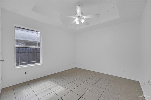 3817 Frontier Dr, Edinburg, TX 78539 - empty room featuring a raised ceiling, light tile patterned flooring, ceiling fan, and baseboards