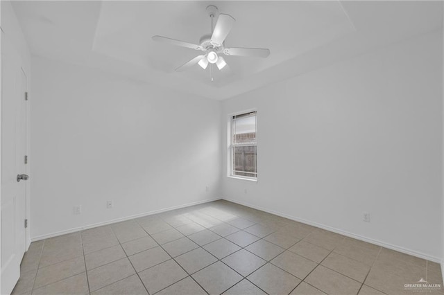 3817 Frontier Dr, Edinburg, TX 78539 - unfurnished room featuring a tray ceiling, light tile patterned floors, a ceiling fan, and baseboards