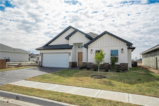 view of front of house with a garage, central AC unit, and a front lawn