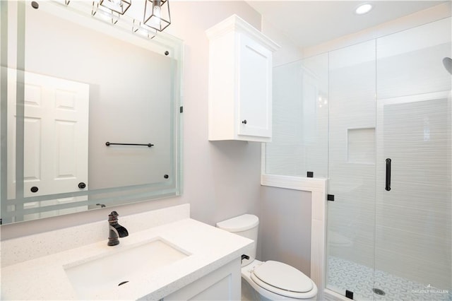 bathroom with vanity, toilet, and a shower with shower door