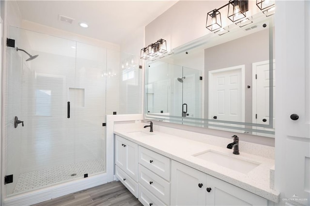 bathroom featuring vanity, wood-type flooring, and a shower with shower door