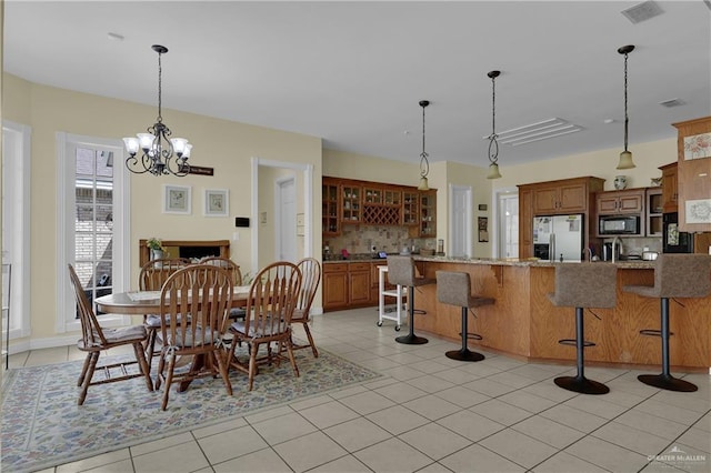 dining area with light tile patterned floors and an inviting chandelier