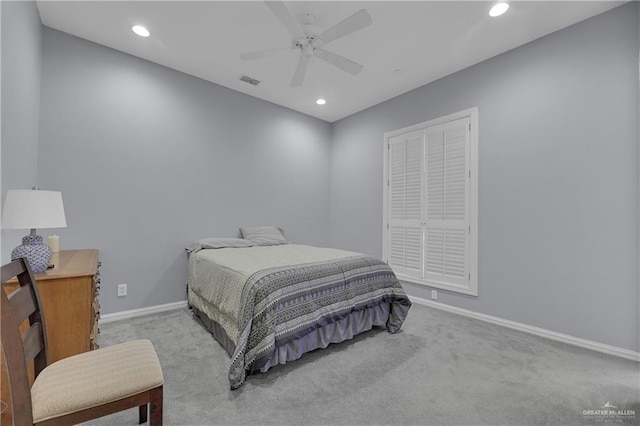 bedroom featuring ceiling fan, light carpet, and a closet