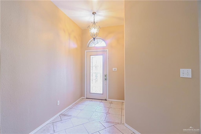 foyer featuring baseboards, a chandelier, and a wealth of natural light