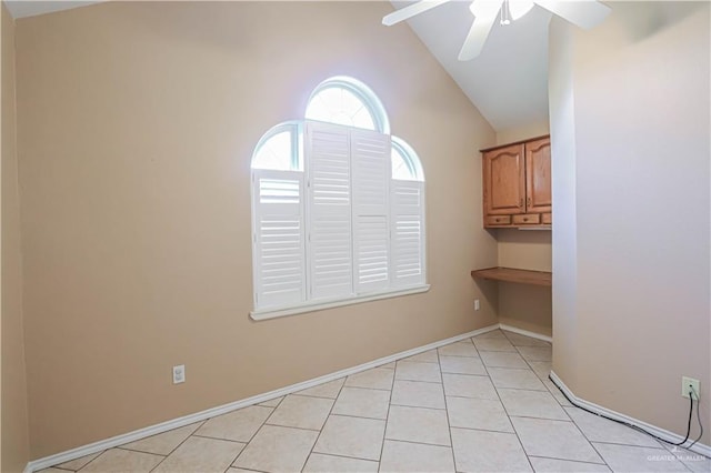 empty room featuring light tile patterned floors, ceiling fan, baseboards, and high vaulted ceiling