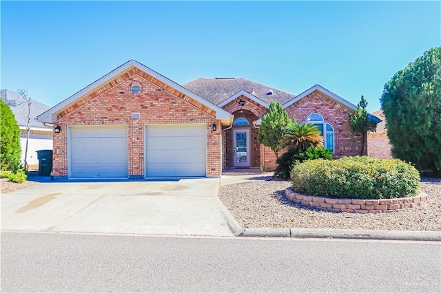 ranch-style house featuring brick siding, driveway, an attached garage, and roof with shingles