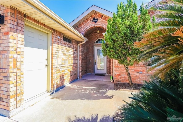 doorway to property featuring brick siding