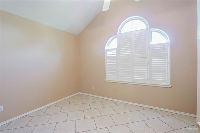 spare room featuring vaulted ceiling and baseboards