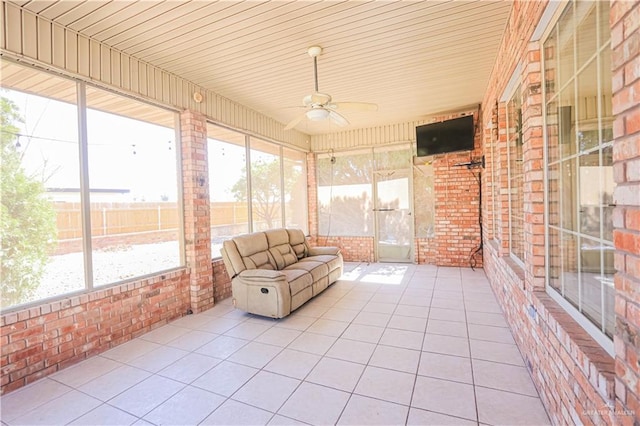 unfurnished sunroom featuring ceiling fan