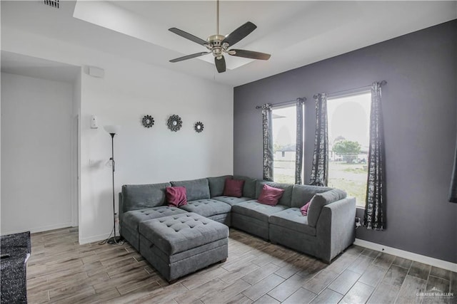 living area with a ceiling fan, baseboards, and wood tiled floor