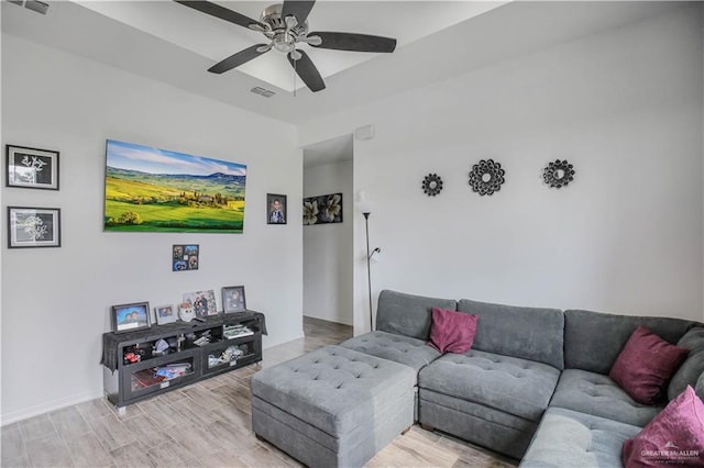 living room with visible vents, a ceiling fan, light wood-style flooring, and baseboards