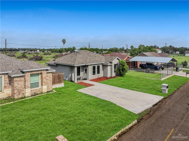 ranch-style house with fence, roof with shingles, a front lawn, brick siding, and a detached carport