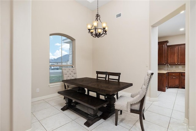 dining space featuring light tile patterned floors, a chandelier, and baseboards