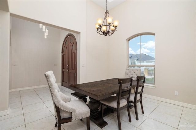 dining area with light tile patterned floors, arched walkways, a chandelier, and baseboards