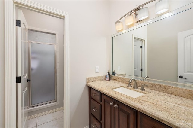 bathroom with tile patterned flooring, vanity, and a shower stall