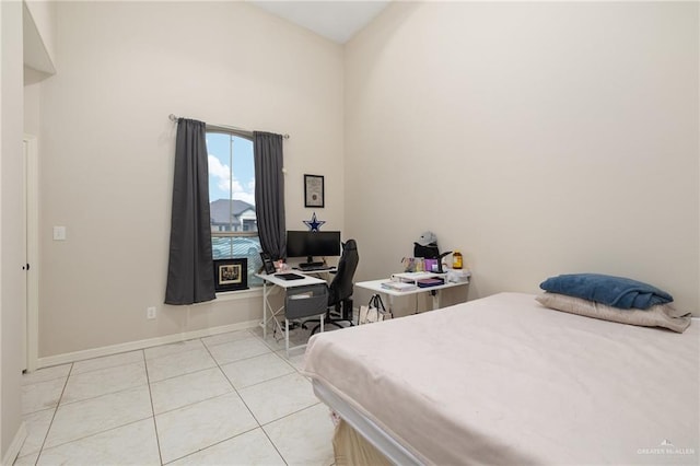 bedroom featuring light tile patterned floors and baseboards