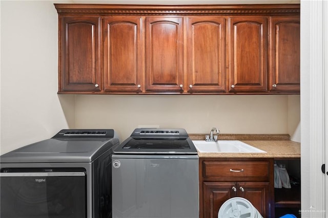 washroom with cabinet space, separate washer and dryer, and a sink