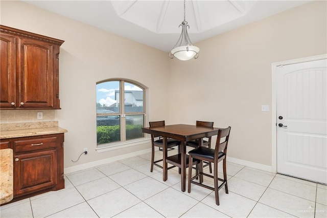 dining space featuring light tile patterned floors and baseboards