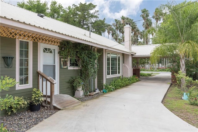 701 S Parker Rd S, La Feria, TX 78559 - view of home's exterior featuring metal roof, driveway, and a chimney