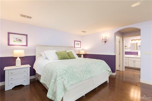 701 S Parker Rd S, La Feria, TX 78559 - bedroom featuring baseboards, arched walkways, and wood finished floors