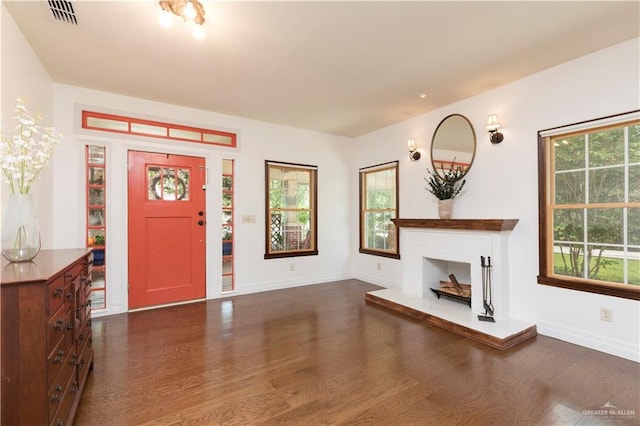 701 S Parker Rd S, La Feria, TX 78559 - foyer with dark wood-type flooring, baseboards, and a fireplace with raised hearth