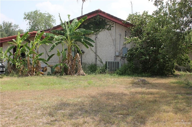 view of home's exterior with a lawn and central air condition unit