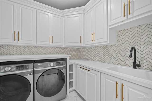 laundry room featuring cabinets, washer and dryer, and sink