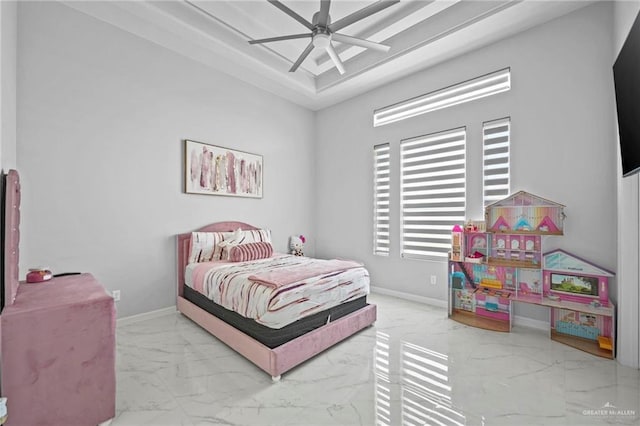 bedroom with ceiling fan and a raised ceiling