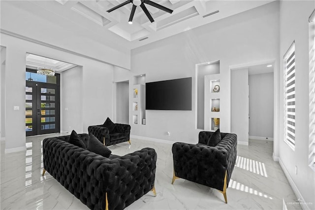 living room featuring a towering ceiling, coffered ceiling, ceiling fan, beam ceiling, and french doors