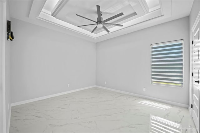 empty room with a raised ceiling and ceiling fan