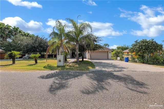 view of front of property featuring driveway, a front lawn, and fence