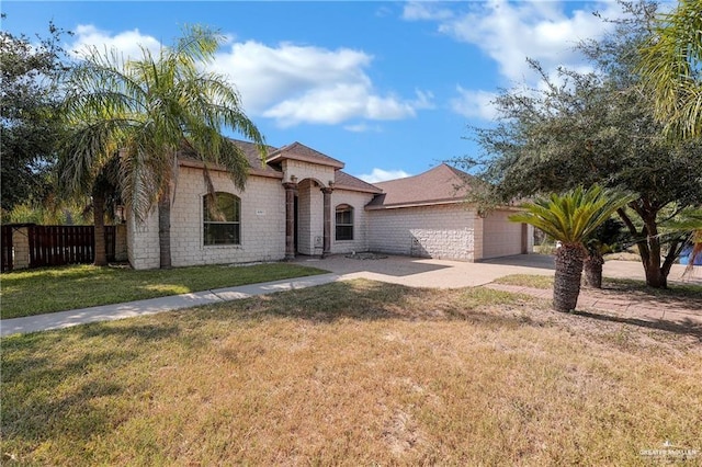 mediterranean / spanish-style home featuring a front yard, fence, concrete driveway, a garage, and brick siding