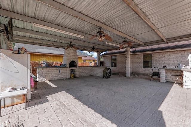 view of patio / terrace featuring ceiling fan, a fireplace, and outdoor dry bar