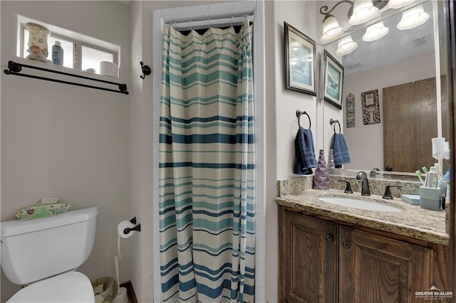 bathroom featuring visible vents, toilet, vanity, and a shower with curtain