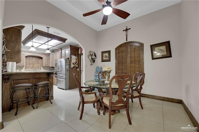 dining space featuring visible vents, arched walkways, light tile patterned floors, baseboards, and ceiling fan